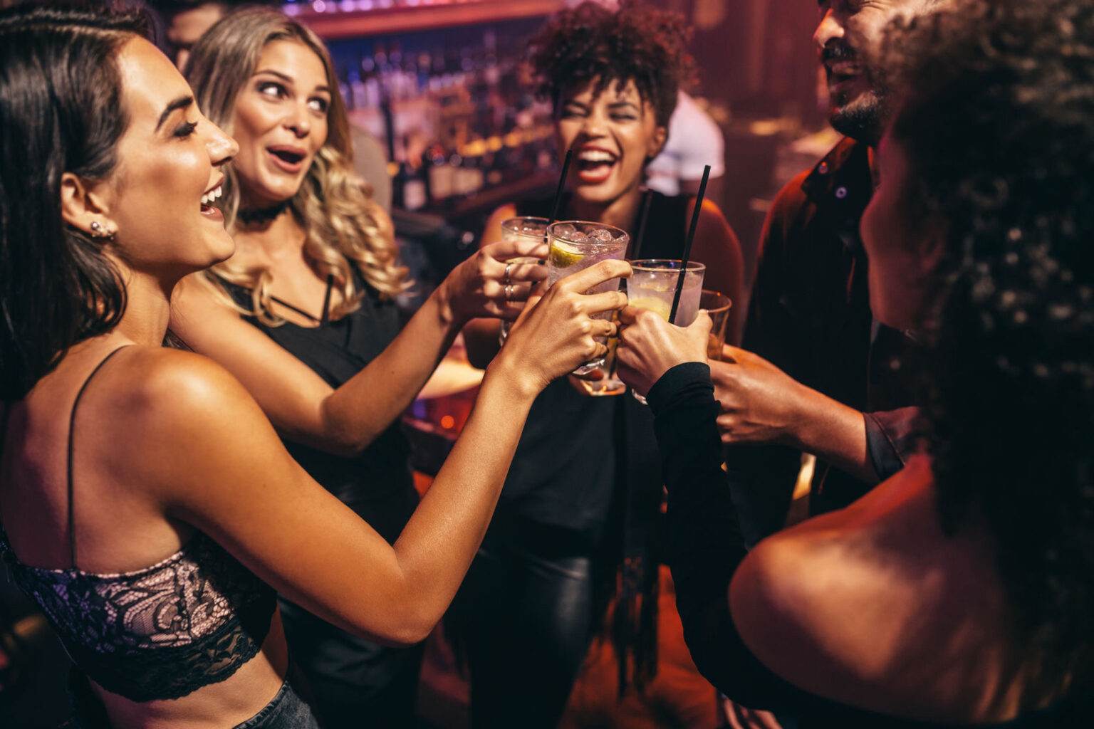 Freundinnen stoßen auf einer Party mit Drinks an
