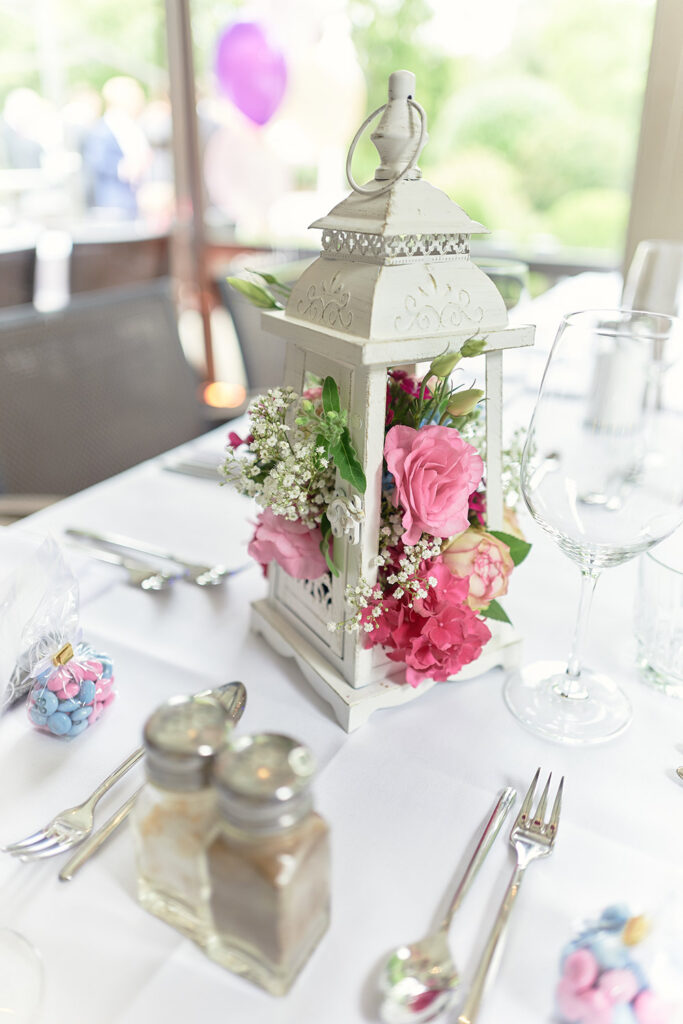 Festlich gedeckter Tisch mit Laterne und rosa Blumen